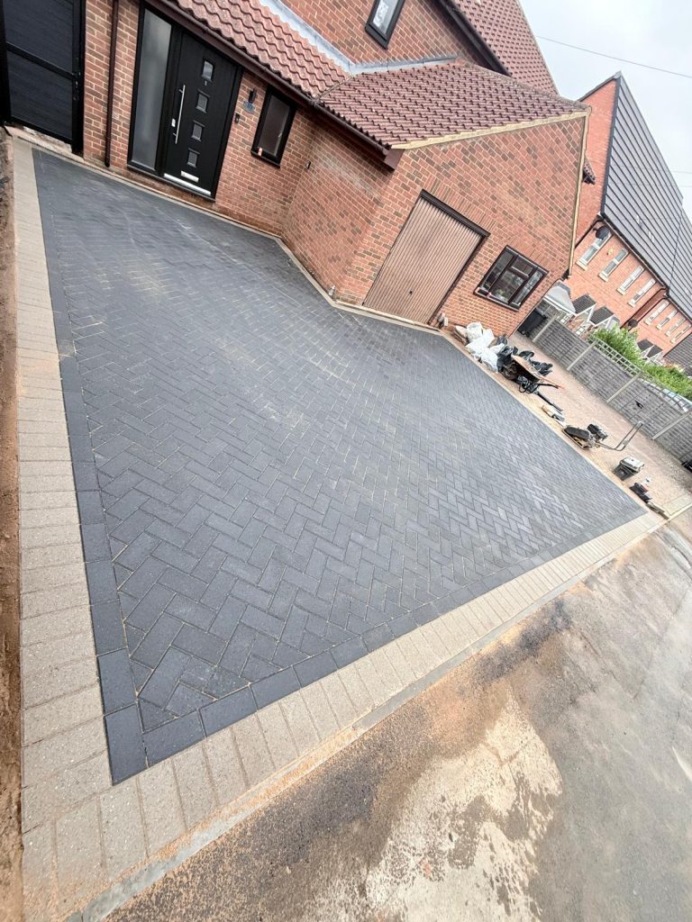Completed 55m² block paving driveway with a charcoal grey herringbone pattern and contrasting border in Windmill Road, Rushden by AAS Group Construction