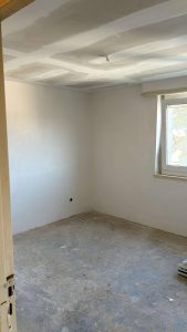 Newly plastered walls and ceiling finishing during interior development of a residential new build project by AAS Group Construction