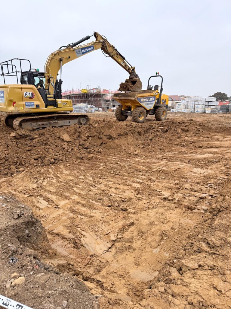 CAT excavator loading a site dumper truck during foundation groundworks and earthmoving in Overstone, Northampton by AAS Group Construction