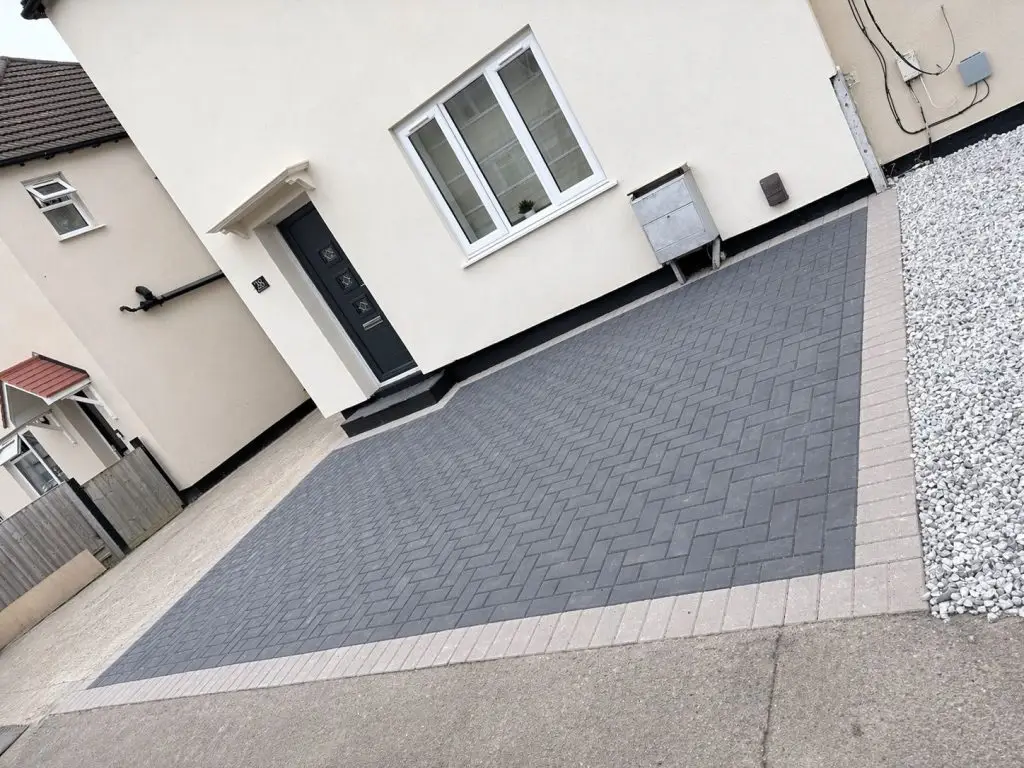 Completed charcoal herringbone block paving driveway with light border and gravel edging in Rothwell Kettering