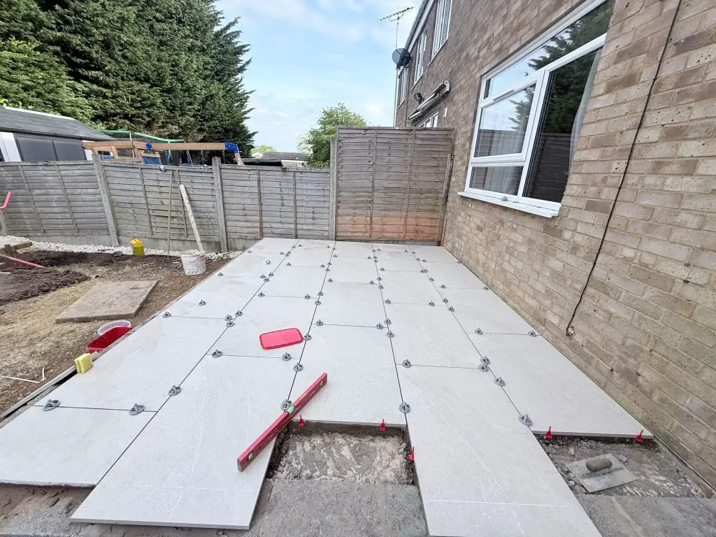 Porcelain paving installation with levelling clips and spirit level alignment in Wellingborough